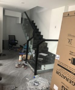 Cầu thang kính không trụ sơn đen đi trên mặt kính